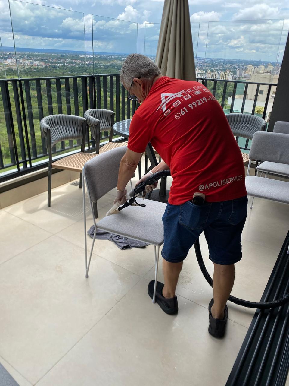 Técnico da ApoliService higienizando cadeira em varanda com vista panorâmica